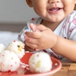 1歳の子がおにぎりを…　※この画像はイメージです／Adobe Fireflyで作成しています
