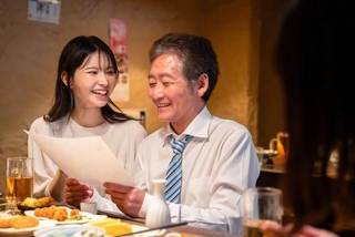 若い女性と二人でお酒を飲む男性※画像はイメージです （maroke/stock.adobe.com）