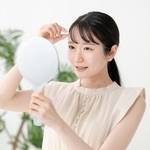 前髪をチェックする女性　※写真はイメージ（Peak River/stock.adobe.com）