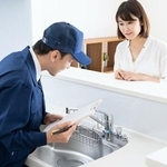 水道を修理する男性とその修理を見守る女性　※画像はイメージです （ ponta1414/stock.adobe.com）