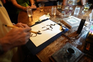 毛筆チャレンジの様子。「Carpe Diem Cafe（カルペディエムカフェ）」にて