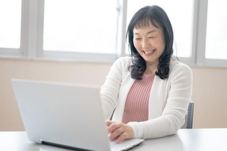 新しい分野の勉強をしている50代女性※画像はイメージです（YUTO PHOTOGRAPHER/stock.adobe.com/）