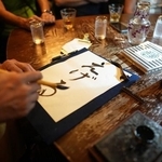 毛筆チャレンジの様子。「Carpe Diem Cafe（カルペディエムカフェ）」にて