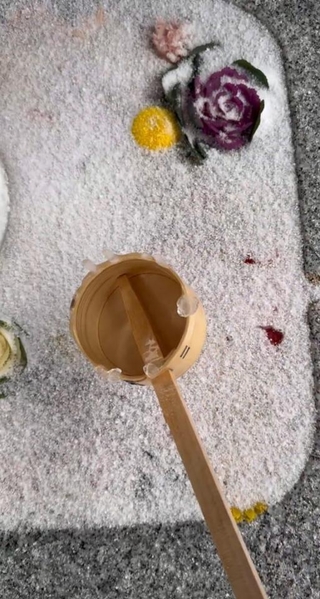 花手水の表面の霜に水をかけていくと…（動画よりキャプチャ、トリミング 画像提供：荘内神社さん）