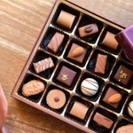 隠していたちょっと高めのチョコを小１の娘さんが見つけて、片肘ついて食べていたという（photoACより「choco❁⃘*.ﾟ」さん撮影、イメージ画像）