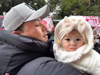 パパに抱っこされ、大きなリボンをつけた娘さん／Narumiさん（@nrm2_1）提供