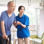 高齢者の歩行介助をする介護士※画像はイメージです（mapo/stock.adobe.com）