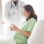 病院のベッドで書面を見る女性※画像はイメージです（Monet/stock.adobe.com）」