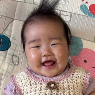 お向かいのおばあちゃんが編んだワンピースを着て、笑顔を見せる生後6カ月の娘／「あーちゃんちゃん」さん（@aydayo221）提供＝画像をトリミングしています