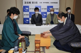 初日の対局を終え、片付けた駒が入った箱を盤上に置く木村一基王位（手前右）。手前左は藤井聡太棋聖＝４日午後、神戸市北区有馬町、旅館「中の坊瑞苑」（撮影・斎藤雅志）