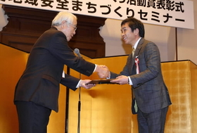 ひょうご地域安全まちづくり活動賞に選ばれ、井戸敏三・兵庫県知事から記念品を受け取る（右）脇水均・神戸新聞神戸市専売会会長=神戸市中央区下山手通４、兵庫県公館（撮影・峰大二郎）