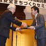 ひょうご地域安全まちづくり活動賞に選ばれ、井戸敏三・兵庫県知事から記念品を受け取る（右）脇水均・神戸新聞神戸市専売会会長=神戸市中央区下山手通４、兵庫県公館（撮影・峰大二郎）