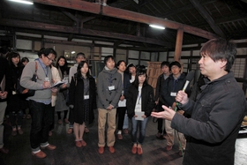 田治米合名会社の田治米博貴社長（右端）から日本酒の醸造について説明を受ける学生ら＝朝来市山東町矢名瀬町（撮影・長谷部崇）