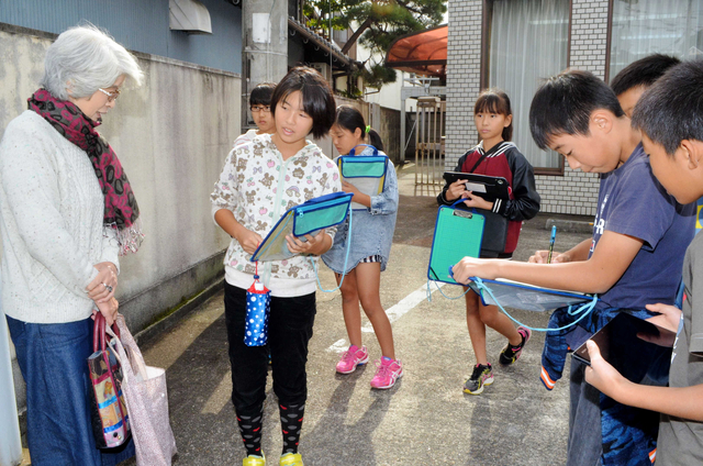 西脇小木造校舎について市民に話を聞く児童ら＝西脇市西脇