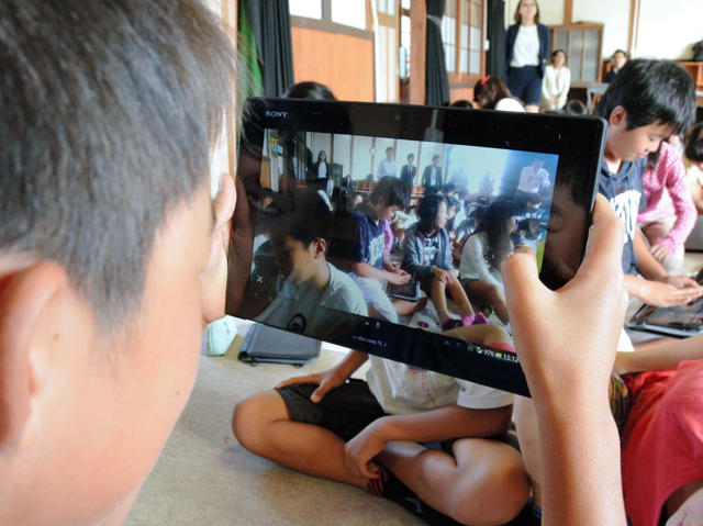 タブレット端末の機能を使い、級友の写真を撮影する児童＝西脇小