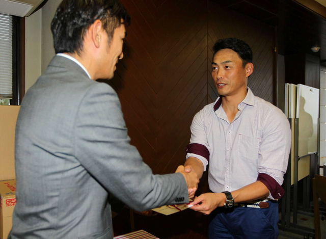 集まった寄付金を手渡す元プロ野球・阪神タイガースの桧山進次郎さん（右）＝神戸市北区道場町