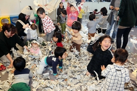 新聞紙の紙吹雪で遊ぶ子どもら＝吉川児童館
