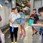 西脇小木造校舎について市民に話を聞く児童ら＝西脇市西脇