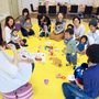 髙田さん（左端）が絵本を読み、和やかな雰囲気に包まれる親子カフェ＝神戸市垂水区小束山手２