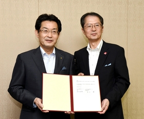 調印した連携協定書を手にする甲南大学の長坂悦敬学長（右）と神戸新聞社の高士薫社長＝２５日午前、神戸市東灘区岡本８（撮影・中西大二）