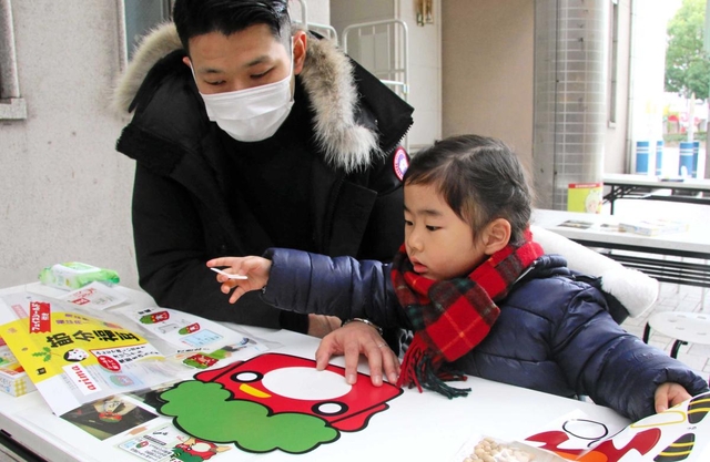 フェースシールドで鬼の面作りを体験する親子＝神戸市中央区元町通６