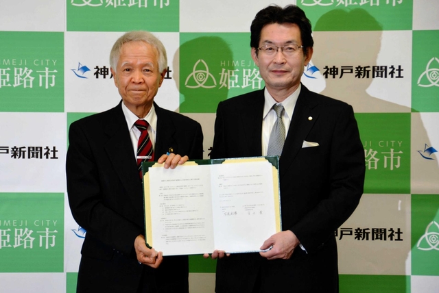 協定書を交わした姫路市の石見利勝市長（左）と神戸新聞社の高士薫社長＝姫路市役所