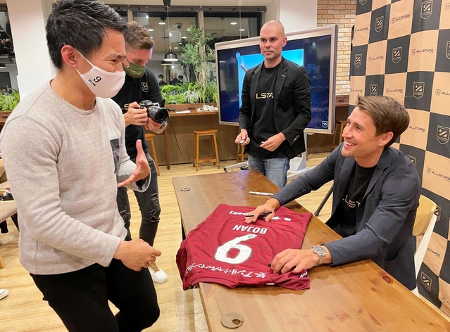 ファンと笑顔で交流するヴィッセル神戸のボージャン・クルキッチ選手（右）＝神戸市中央区磯上通４、１２０ワークプレイス神戸