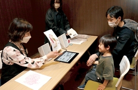複数の音源の中から、自作した塗り絵の色味に合った音楽を探す体験者