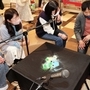 マイクに向かって発した声の振動で砂が動く様子を楽しむ参加者＝いずれもＯＳシネマズ神戸ハーバーランド