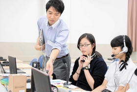 国際交流を学ぶ授業で高校生に指導する五十嵐社長（左）＝西宮市内