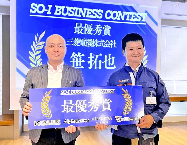 審査委員長の麻生要一さん（左）から最優秀賞のパネルを受け取る笹拓也さん＝アンカー神戸