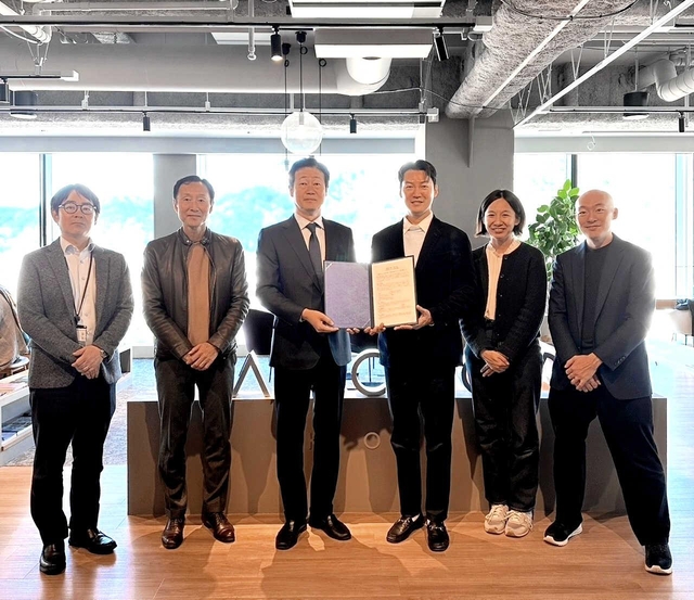 合意書を交わしたＵＤインパクトのキム・ジョンホン最高経営責任者（ＣＥＯ、中央右）と神戸新聞地域総研の稲川勉所長（同左）＝神戸市中央区加納町４