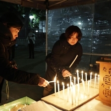 ろうそくに灯をともし追悼する人たち＝１７日午前５時４８分、神戸市長田区本庄町２、大国公園