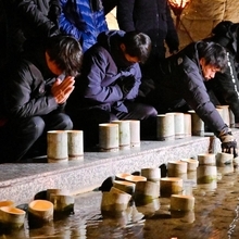 犠牲者を悼み灯籠を流す参列者＝１７日午前５時３４分、淡路市小倉、北淡震災記念公園