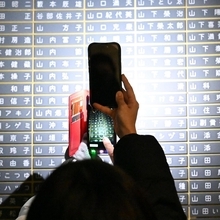 スマートフォンで銘板を撮影する人＝１７日午前６時５５分、神戸市中央区加納町６、東遊園地（撮影・斎藤雅志）