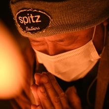 竹灯ろうの前で祈る男性＝１７日午前５時４３分、神戸市中央区加納町６、東遊園地（撮影・大田将之）