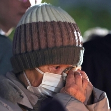 竹灯ろうの前で涙をぬぐう参列者＝１７日午前６時１８分、神戸市中央区加納町６、東遊園地（撮影・中西幸大）