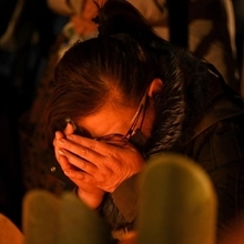 竹灯ろうの前で涙を拭う女性＝１７日午前５時４７分、神戸市中央区加納町６、東遊園地（撮影・大田将之）