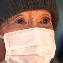 竹灯ろうの前で涙を浮かべる参列者＝１７日午前６時１７分、神戸市中央区加納町６、東遊園地（撮影・中西幸大）