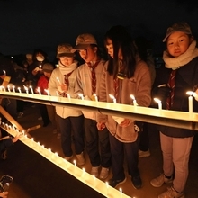 慰霊碑前で献灯する追悼行事の参加者たち＝１７日午前５時５８分、神戸市東灘区本山北町３、本山第一小（撮影・三浦拓也）