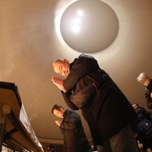 震災で焼失した後、再建された円形の聖堂で手を合わせる人ら＝１７日午前６時０１分、神戸市長田区海運町３、カトリックたかとり教会（撮影・小林良多）