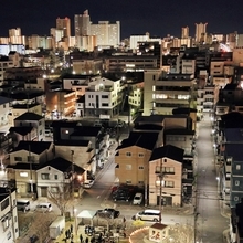 復興したまちの一角で、「１．１７」のろうそくに集う人たち＝１７日午前６時２０分、神戸市長田区御蔵通５から（撮影・中西大二）