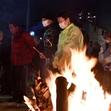 たき火のそばで黙とうする住民ら＝１７日午前５時５０分、神戸市兵庫区松本通３、川池公園（撮影・三津山朋彦）