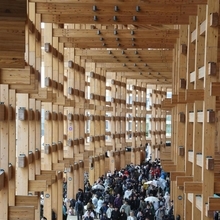 雨宿りも兼ねて大屋根リング下を歩く人たち＝１３日午後、大阪市此花区夢洲（撮影・笠原次郎）