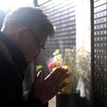 銘板に向い手を合わせる人＝１７日午前６時１１分、神戸市中央区加納町６、東遊園地