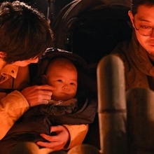 追悼行事の竹灯籠を見つめる人たち＝１７日午前６時１５分、神戸市中央区加納町６、東遊園地（撮影・風斗雅博）