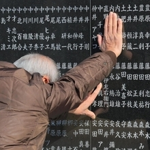 泣き人の名前に手を当て、むせび泣く男性＝１７日午前１０時１８分、西宮市奥畑、西宮震災記念碑公園（撮影・吉田敦史）