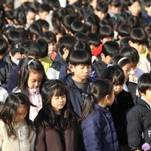 亡くなった８人の在校生らの冥福を祈る児童＝１７日午前９時０２分、芦屋市精道町、精道小学校（撮影・小林良多）