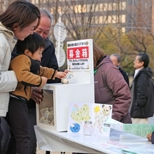 「１．１７のつどい」存続のため子どもたちが寄付を呼びかけ、家族連れが応じていた＝１７日午後４時２２分、神戸市中央区加納町６、東遊園地（撮影・笠原次郎）