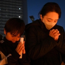 犠牲者を追悼するイベントで発生時刻に手を合わせる人たち＝１７日午後５時４６分、神戸市長田区若松町４、ＪＲ新長田駅前（撮影・風斗雅博）